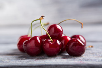 Dark red cherries. Cherries on gray wooden surface. Juicy berries from the garden. Fruit of summer.
