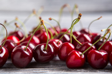 Lots of cherries. Clean berries on wooden surface. High amount of vitamin A. Reduce level of cholesterol.