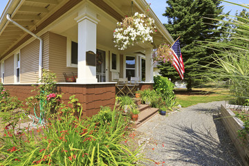 American craftsman house exterior. Cozy covered porch with white columns.