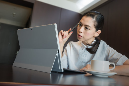 business woman thinking new idea work plan, hold pen on hand. sitting using tablet Laptop Computer.
