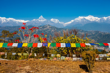 Tibetan prayer flags with view of Phewa lake and Annapurna mount - obrazy, fototapety, plakaty