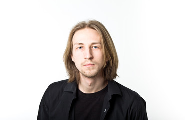 Portrait of young man with long blond hair, black shirt, white b