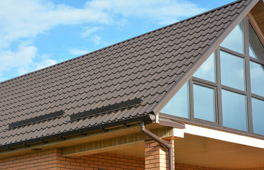 Fototapeta premium Building Modern House Construction with metal roof, rain gutter system and roof protection from snow board, snow bar (Snow guard). Roof Snow Guards: Building Materials & Supplies