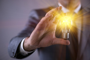 Young businessman with light bulb in idea concept