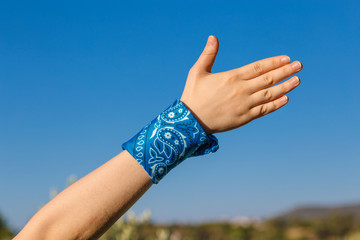 female hand with blue bandana