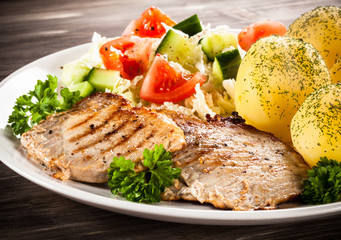 Grilled steaks, boiled potatoes and vegetable salad