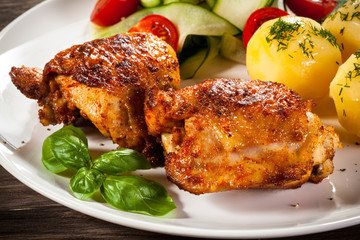 Barbecued chicken legs with boiled potatoes and vegetables 