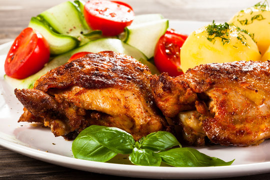 Barbecued chicken legs with boiled potatoes and vegetables 