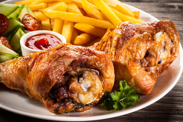 Grilled turkey legs with chips and vegetables