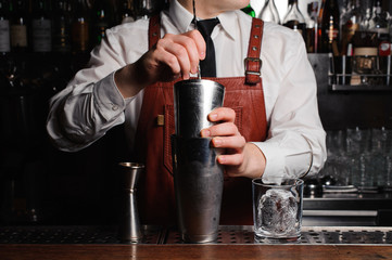 Bartender is stirring cocktails on the bar counter
