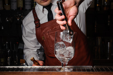 Bartender putting broken ice in a glass