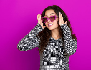 young woman beautiful portrait, posing on purple background, long curly hair, sunglasses in heart shape, glamour concept