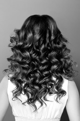 Fototapeta premium Fashion portrait of young woman with magnificent curly hair. Per