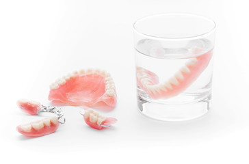Set of Denture in glass of water on white background