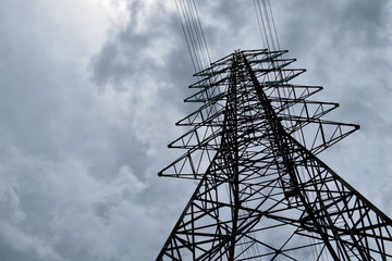 Silhouette of electricity post in cloudy sky,low angle shot.high voltage electric pole,high voltage power supply,high voltage power line. 

