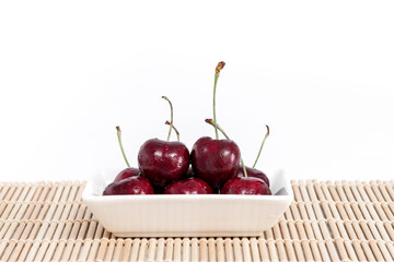 Sweet fresh cherry on dish with white background