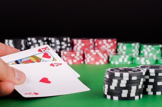 king, ace, black, red and green casino chips on table