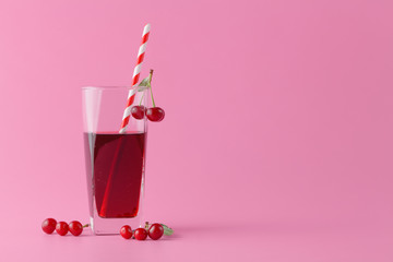 Glass of fresh juice with cherries on bright background