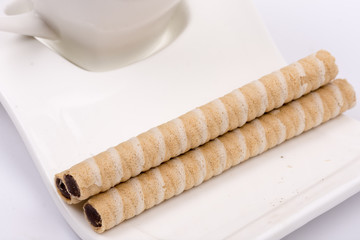 Wafer chocolate cream rolls on the coffee plate