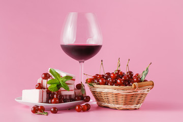 Cherry homemade liquor in a glasses on pink background and cherr