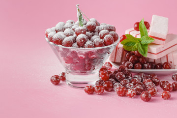Milk glass and dusted powdered sugar with cherries and mint