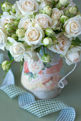 Beautiful fresh beige roses flowers in a vase .