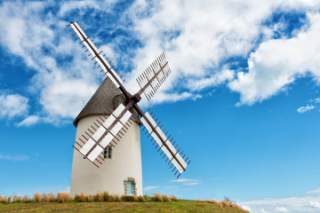 Fototapeta na wymiar ancient european windmill restored on the top of a hill