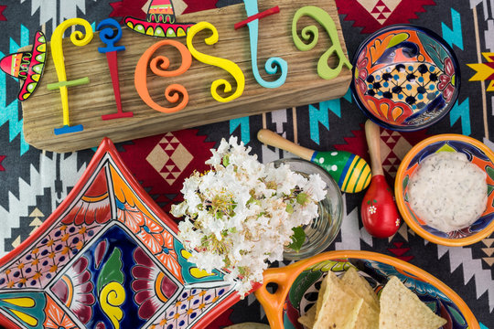 Mexican fiesta table decoration with  colorful painted letters, bright pottery.