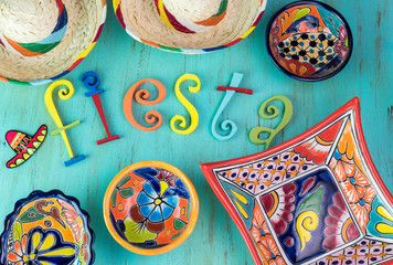 Mexican fiesta table decoration with  colorful painted letters, bright pottery and sombreros.