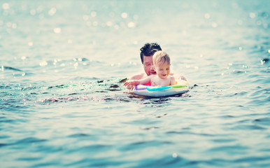 Fototapeta na wymiar Father and son swimming at the sea