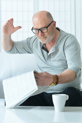 portrait of senior man with newspaper 