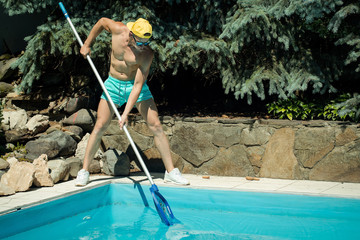 sexy muscular man cleaning swimming pool