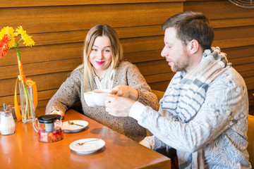 Romantic young couple drinking tea outdoors seated at the restaurant enjoying a relaxing conversation