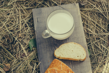 bread and milk cup on wooden board
