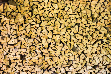 Brown color wood background. Horizontal image of many dry chopped firewood in storage ready for use.