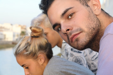 CLOSE UP OF A BOY AND TWO TEENS IN THE BACKGROUND