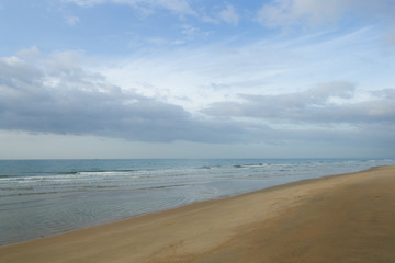 lonely sea beach on cloudy blue sky day in rainy season