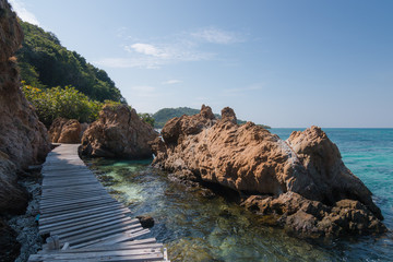 wood bridge for sightseeing sea beside by rock
