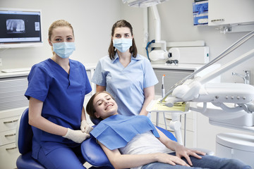 happy female dentist with patient girl at clinic