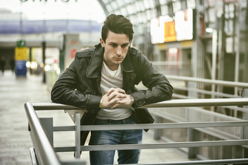 Attractive young man inside modern building, station or airport or office complex