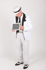 Senior in weißem Anzug hält Tablet / Computer mit Platz für Text / Symbol