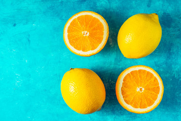 Lemons and oranges on the cyan background top view