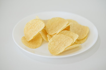snack food of potato chips crispy  in white ceramic bowl  on white background