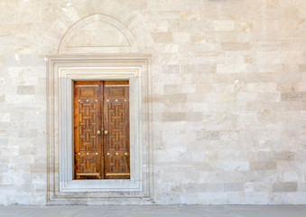 Fototapeta na wymiar Old Wooden Door on Grunge sandstone Wall. Temple.