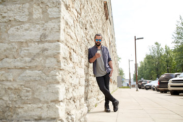 man texting message with smartphone on city street