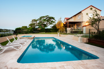 Fototapeta na wymiar Light blue water swimming pool of a modern mansion