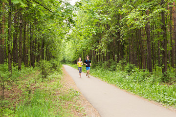 Fototapeta premium Couple running outdoors. Woman and man runners jogging together outside in full body length.