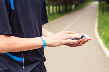 Man using fitness bracelet during morning run