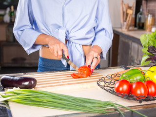 woman slicing tomato on kitchen