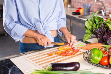 woman slicing carrot on kitchen board